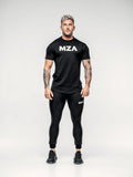 This is a full body shot of shane wearing the new standard long line t shirt paired with the new standard joggers in black.  Shane is facing the camera with his hands by his sides