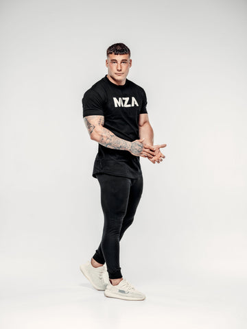 This is a full body shot of Lewis wearing the new standard long line t-shirt in black paired with the new standard joggers in black
