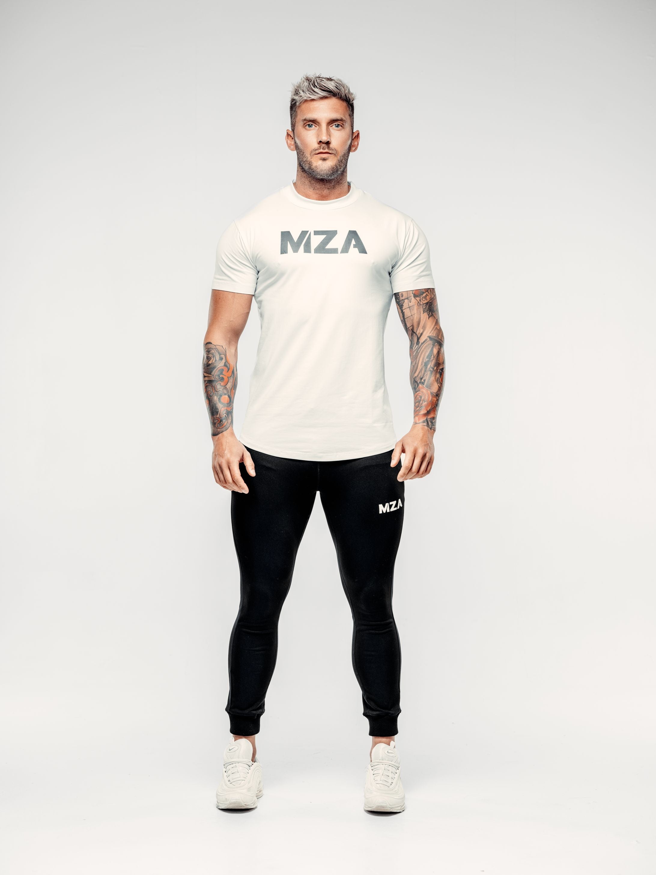 This is a full body shot of shane wearing the new standard long line t shirt in white paired with the new standard joggers in black. Shane is facing the camera with his hands by his sides