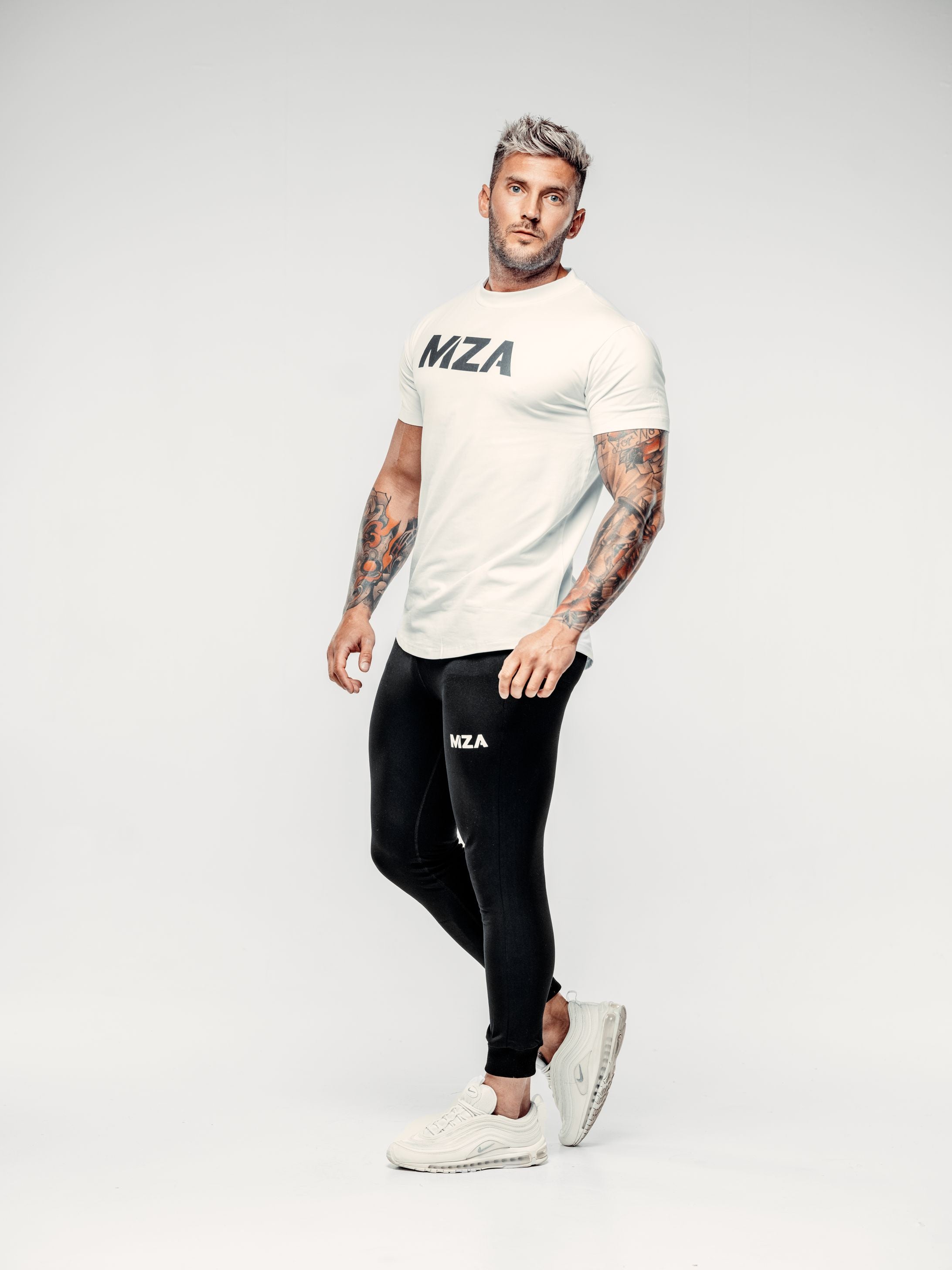 This is Shane mid step looking at the camera wearing the new standard long line t-shirt in white with the new standard long line joggers in black