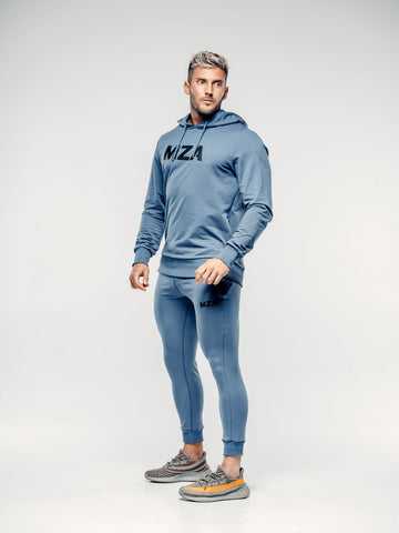 This is a 45 degree angle full body shot of Shane wearing the new standard hoodie in blue steel.  Shane is wearing the matching new standard joggers in blue steel
